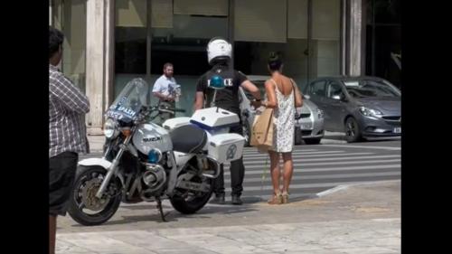 αστυνομικός βοηθά γυναίκα να περάσει διάβαση